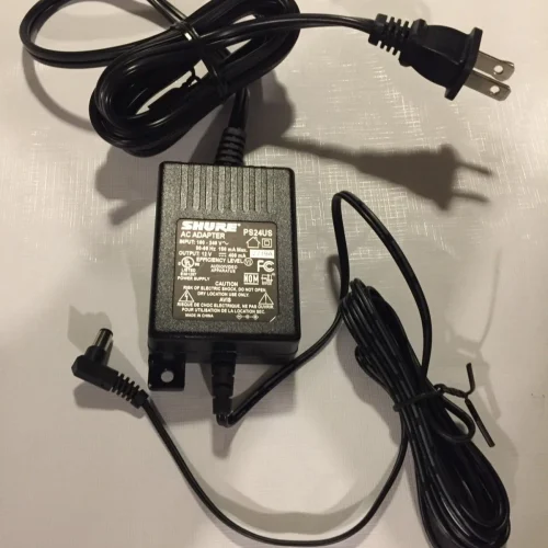 Shure PS24US AC adapter USA Pre-Owned with 12V output for wireless receivers. Stable switching power supply for professional audio systems with protection features.